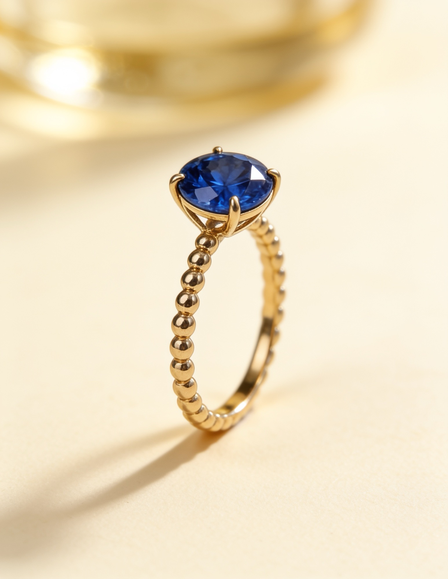 A blue sapphire ring on a beaded gold band